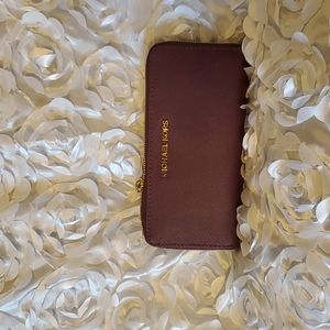 Michael Kors burgundy wallet with zipper.